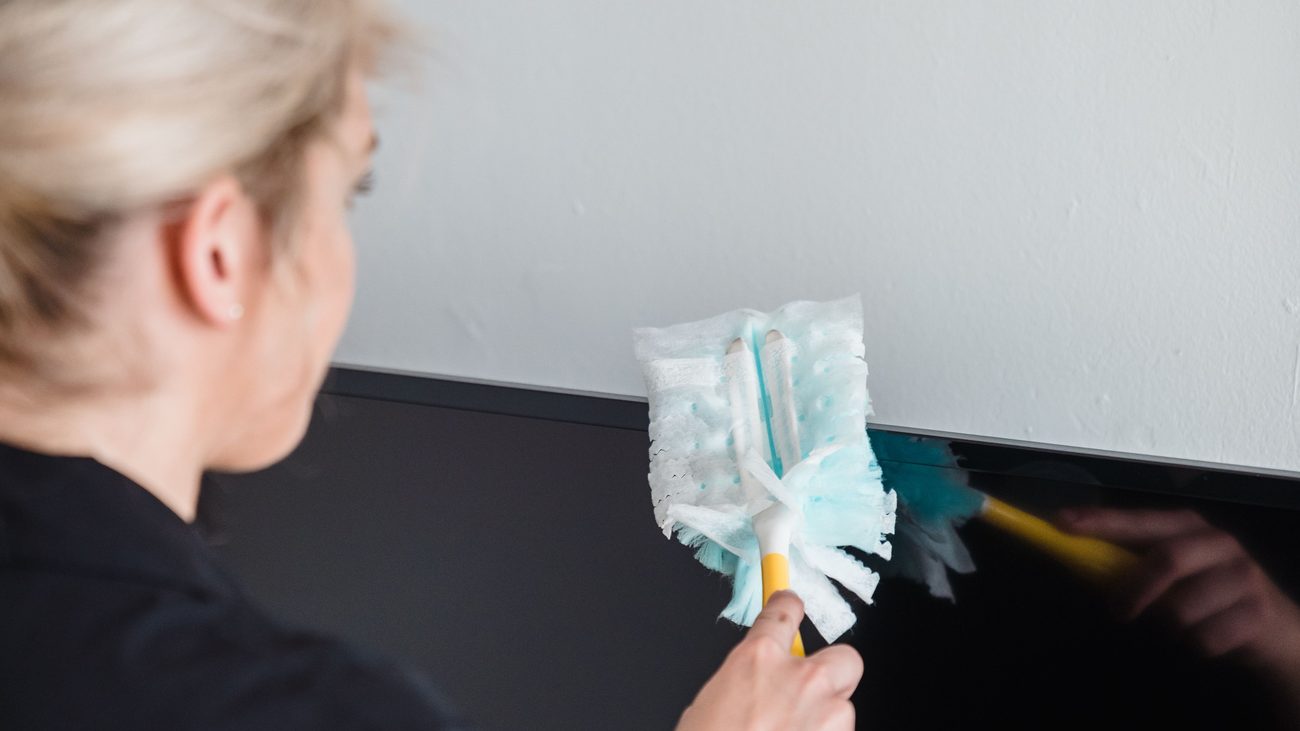 Cleaning team member carefully dusting office equipment